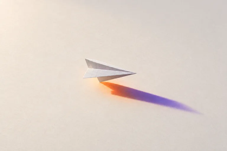 A paper plane folded from an invoice in raking light