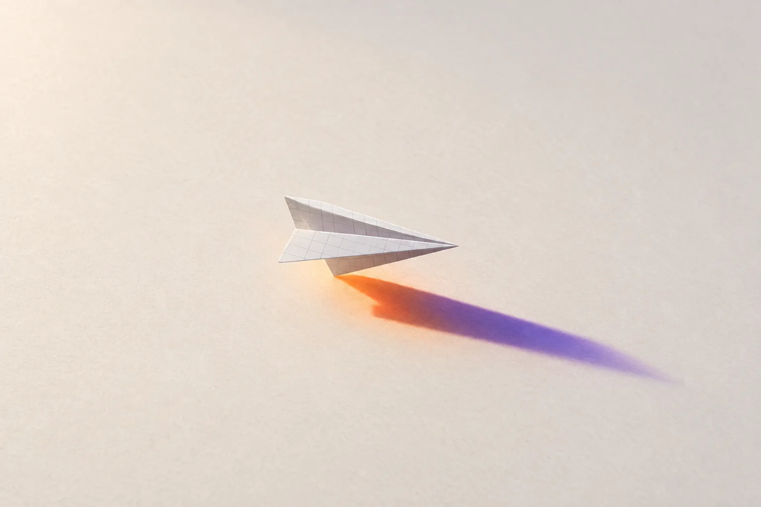 A paper plane folded from an invoice in raking light